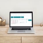 Screenshot Microsoft Dynamics 365 Business Central und smartPORJECT auf einem Laptop auf einem Holztisch mit ruhigem Hintergund